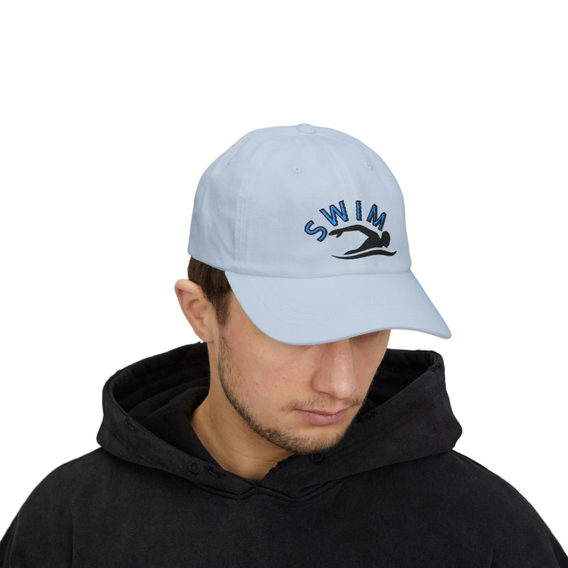 Man wearing a light blue embroidered classic dad cap hat with a Swim text and graphic