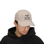 Man wearing a stone baseball cap featuring a graphic on the front that reads BORN TO SKATE with a black skateboard silhouette and colorful lettering for SKATE.