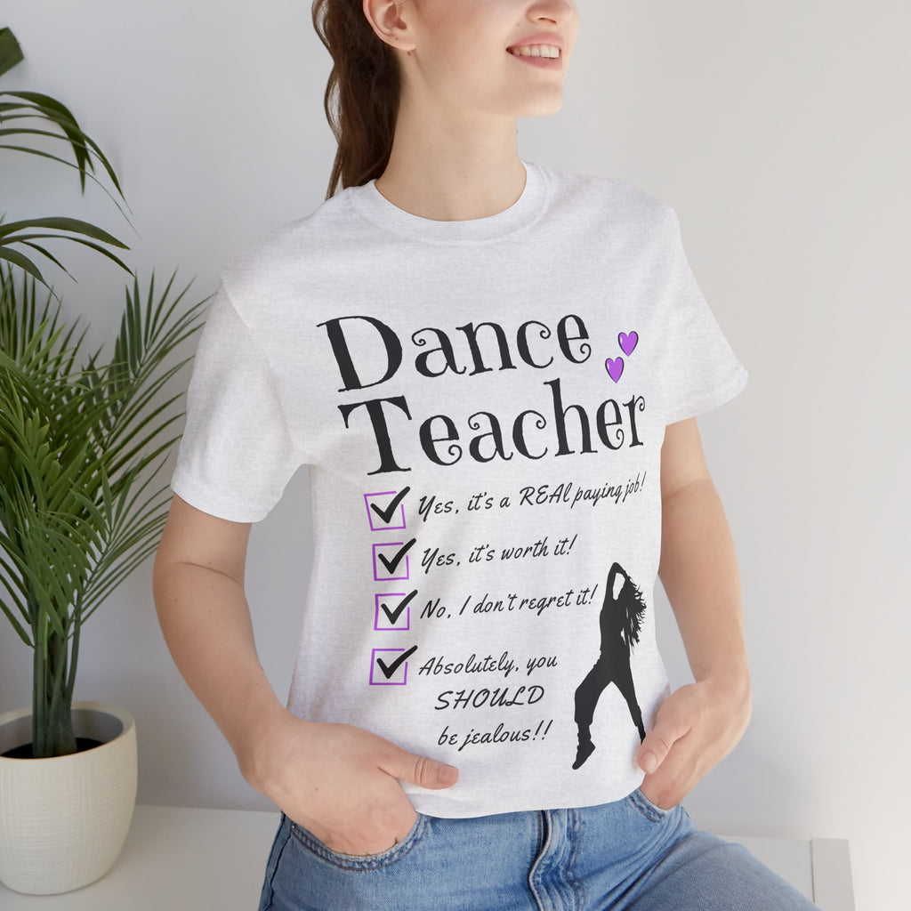 Woman wearing an ash short-sleeve graphic t-shirt featuring the text Dance Teacher with a jazz, hip hop dancer silhouette.