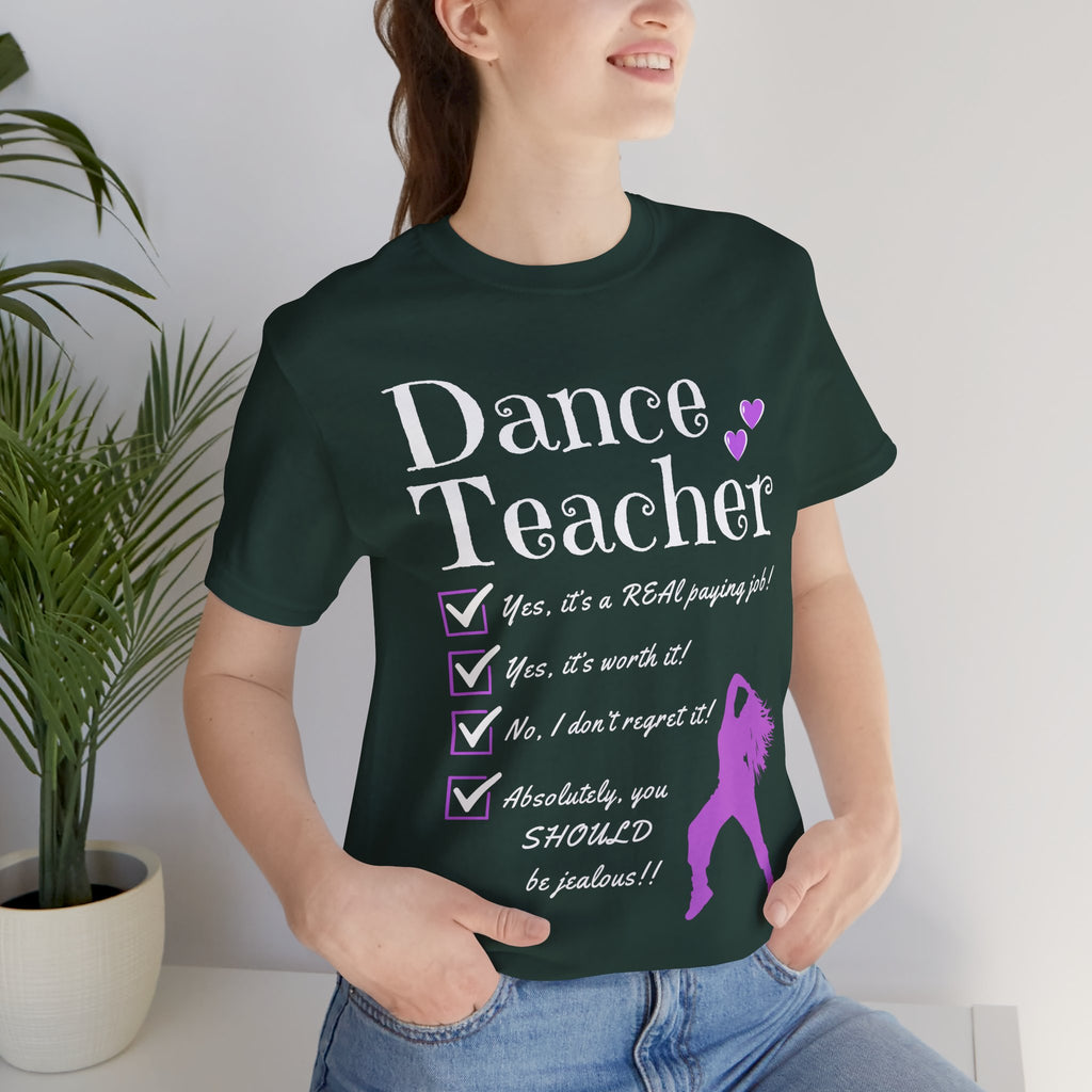 Woman wearing a forest green short-sleeve graphic t-shirt featuring the text Dance Teacher with a jazz, hip hop dancer silhouette.