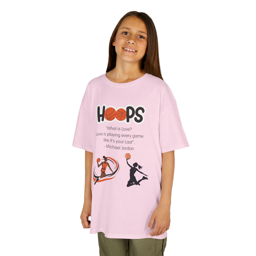 Young girl wearing a youth Gildan 5000B heavy cotton t-shirt in light pink featuring a Girls Basketball design