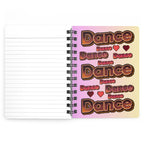 A spiral-bound lined notebook shown open, with the left page blank and lined and the right cover featuring repeated retro-style 'Dance' text in brown, pink, and cream tones.