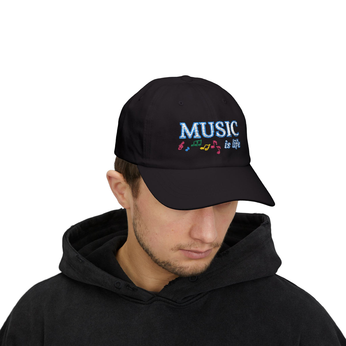 Man wearing a black cap with an embroidered MUSIC IS LIFE text and musical notes graphic.