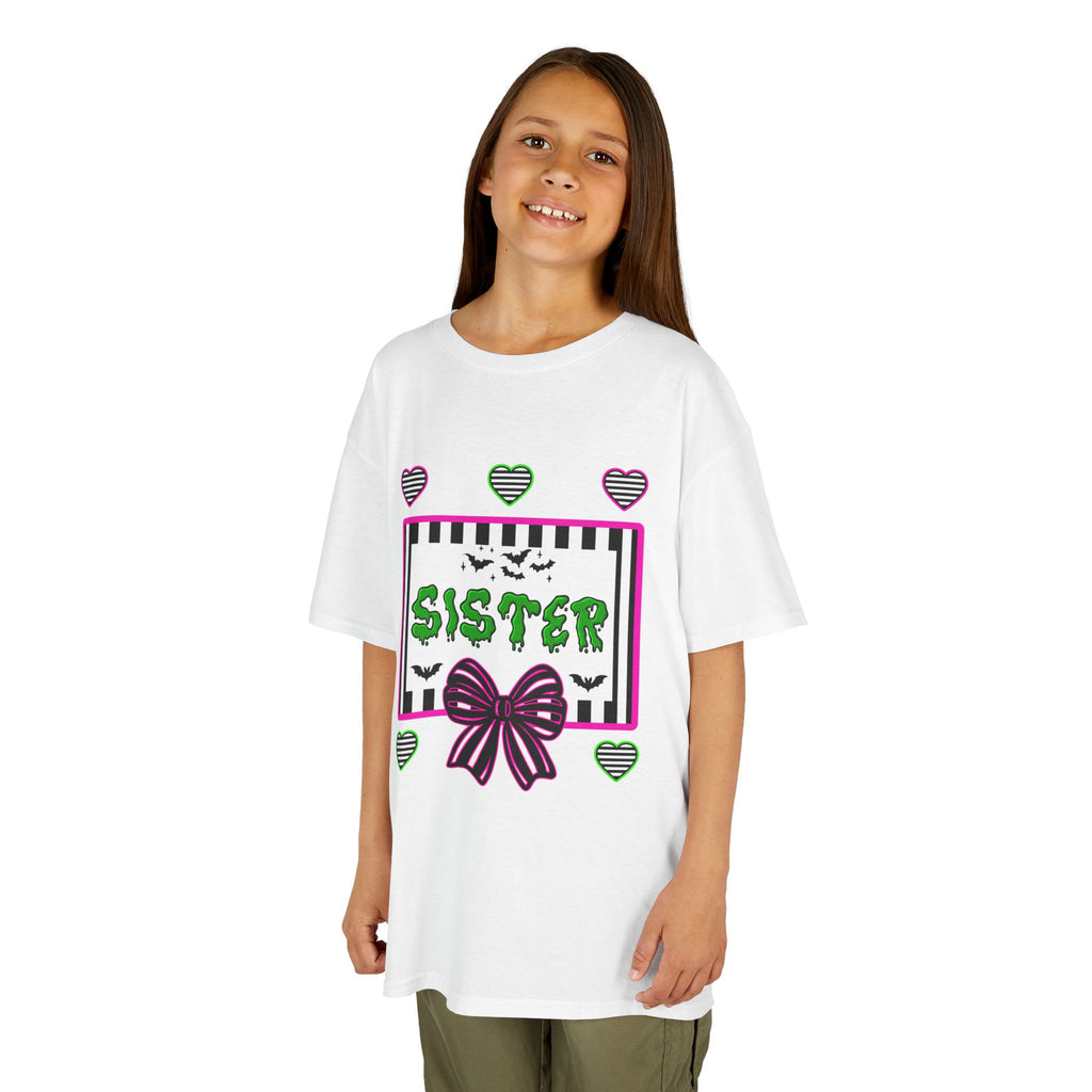 A young girl wearing a white t-shirt featuring a colorful Beetlejuice inspired Halloween-themed graphic with the word SISTER on the front. 