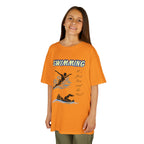 Young girl wearing a youth Gildan 5000B heavy cotton t-shirt in tennessee orange with a Swimming text and graphic