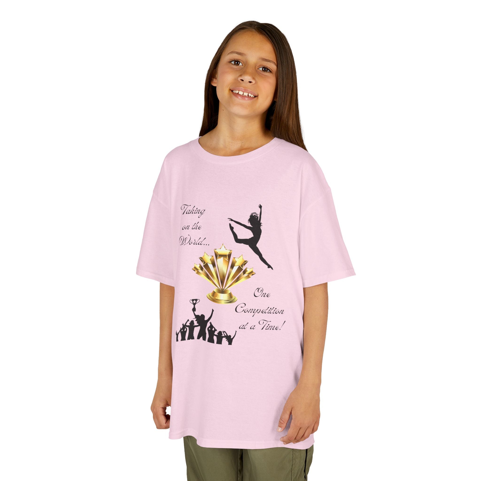 Young girl wearing a youth Gildan 5000B heavy cotton t-shirt in light pink with a Dance Competition theme