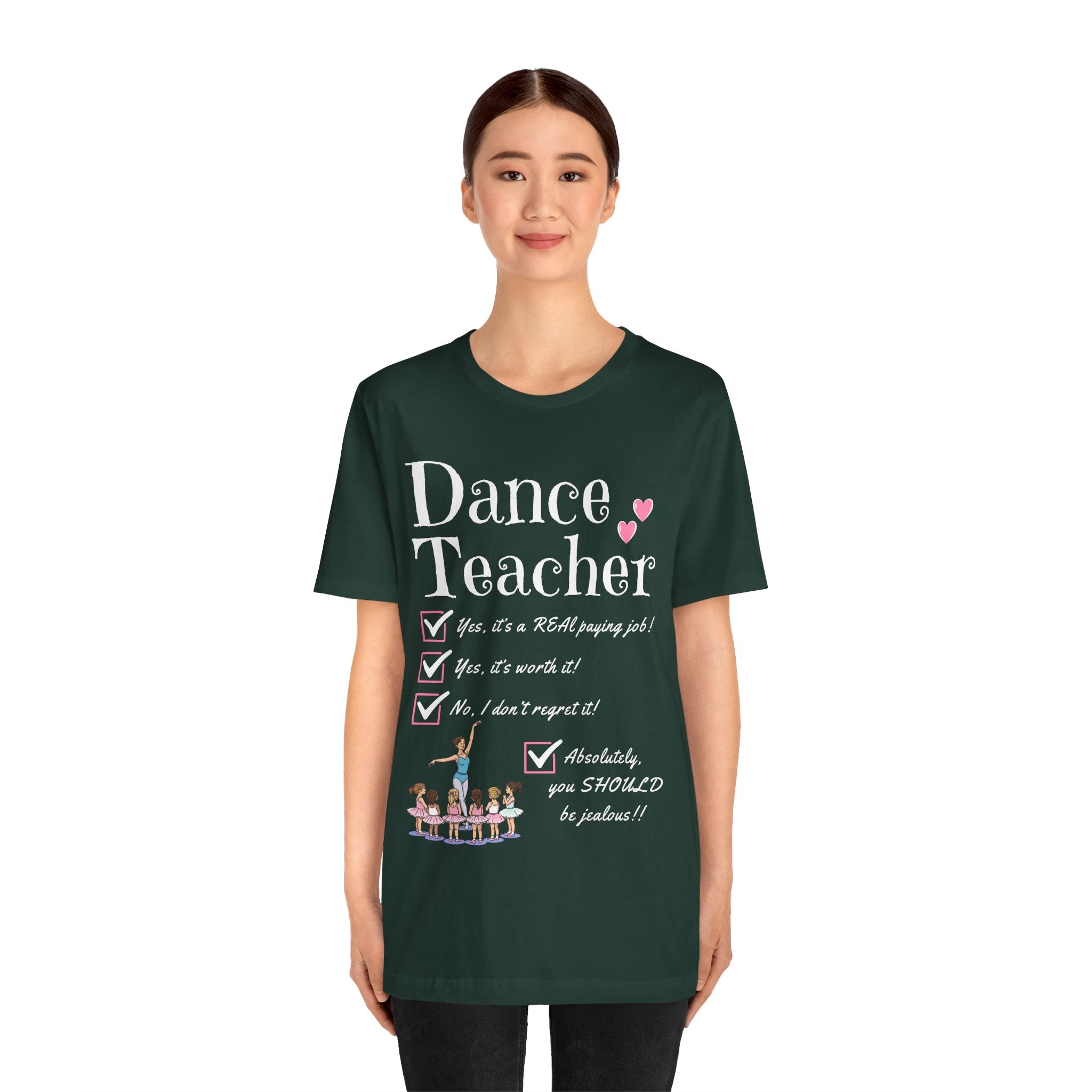 A young woman wearing a forest green short-sleeve crewneck t-shirt featuring a text that reads Dance Teacher and a ballet class graphic.