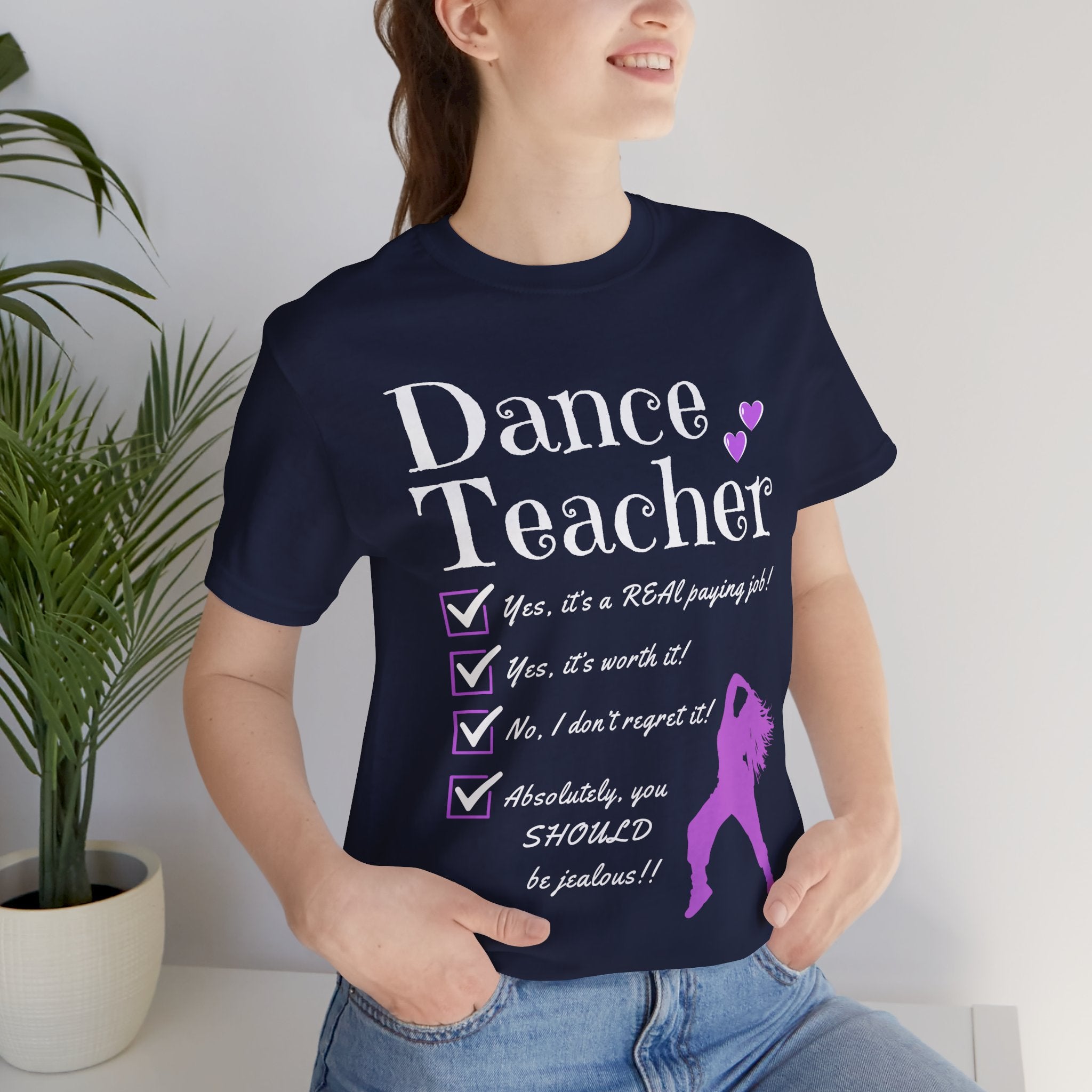 Woman wearing a navy short-sleeve graphic t-shirt featuring the text Dance Teacher with a jazz, hip hop dancer silhouette.