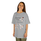 Young girl wearing a youth Gildan 5000B heavy cotton t-shirt in sport grey with a Martial Arts text and graphic