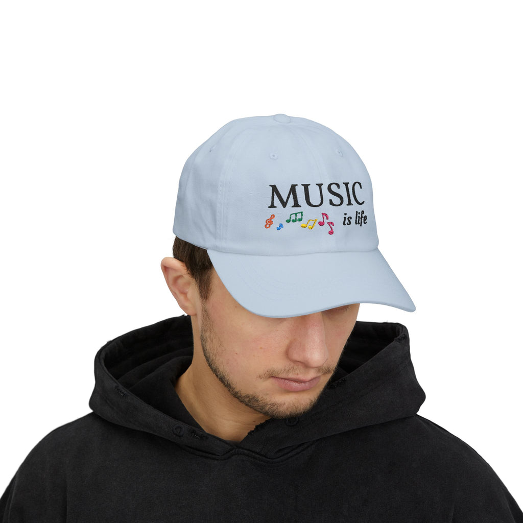 Man wearing a light blue embroidered classic dad cap hat with a Music is Life text and graphic