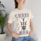 A woman wearing a natural colored graphic t-shirt with CHEER GO TEAM MOM text and graphic on the front.
