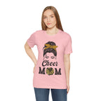 Woman wearing a pink short-sleeve crewneck t-shirt featuring a Cheer Mom silhouette graphic print with text.