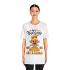 A woman wearing a white short-sleeve t-shirt with a Happy Thanksgiving graphic featuring a ballerina scarecrow design.