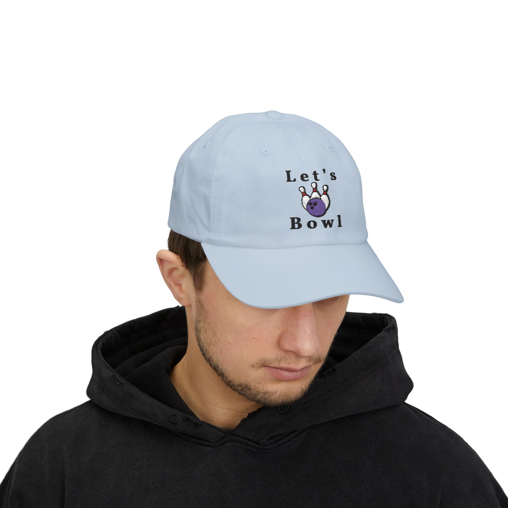 Man wearing a light blue embroidered classic dad cap hat with Let's Bowl text and graphic