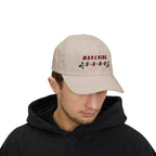 Man wearing a stone embroidered classic dad cap hat with a Marching Band text and musical note graphic 