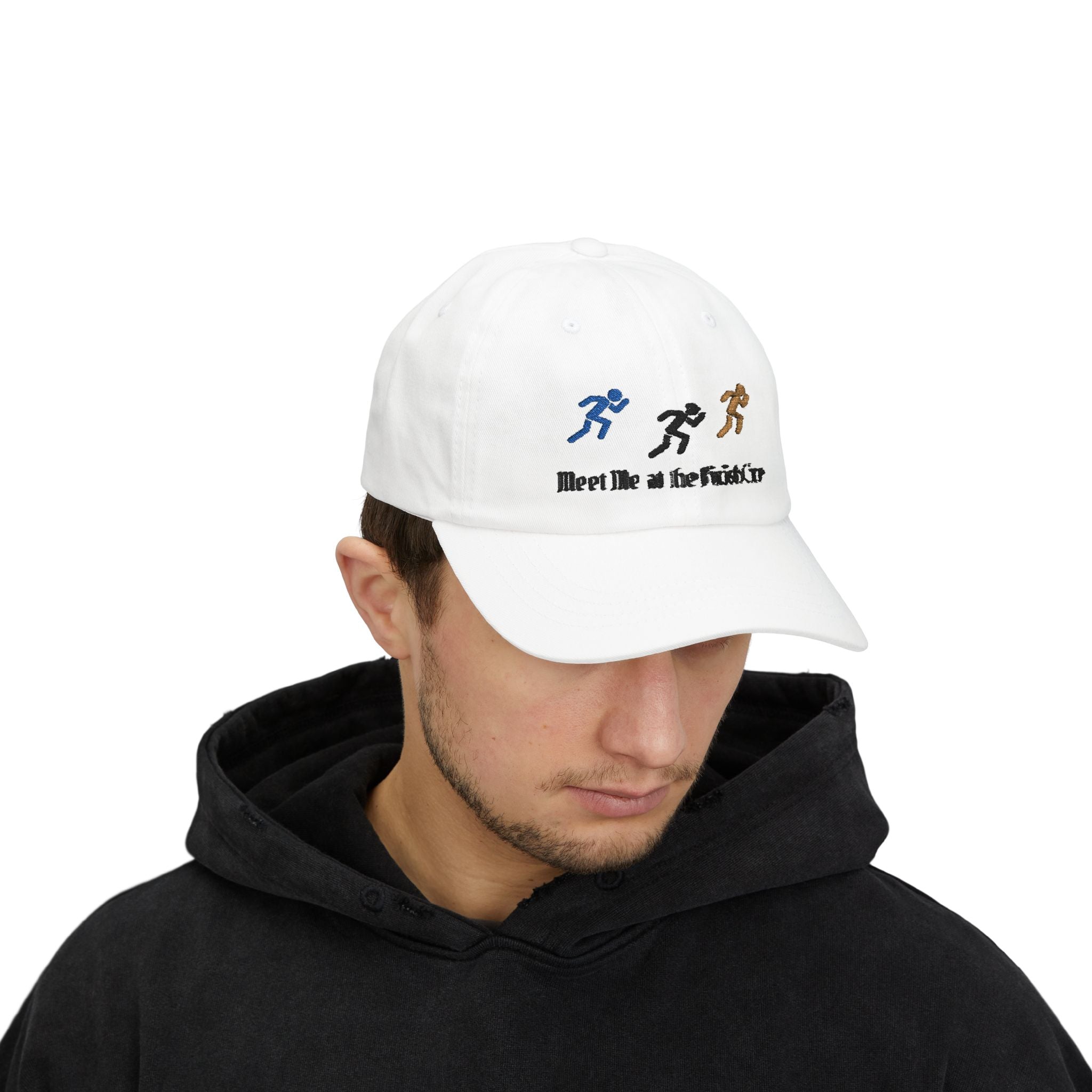 Man wearing a white baseball cap featuring embroidered running figures in blue, black, and tan above the text Meet Me at the Finish Line.