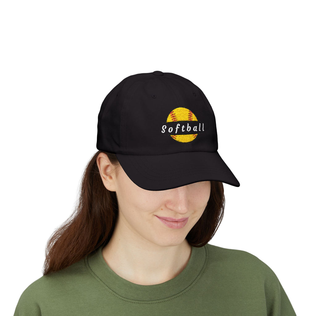 Woman wearing a black cap with an embroidered yellow softball graphic and text.