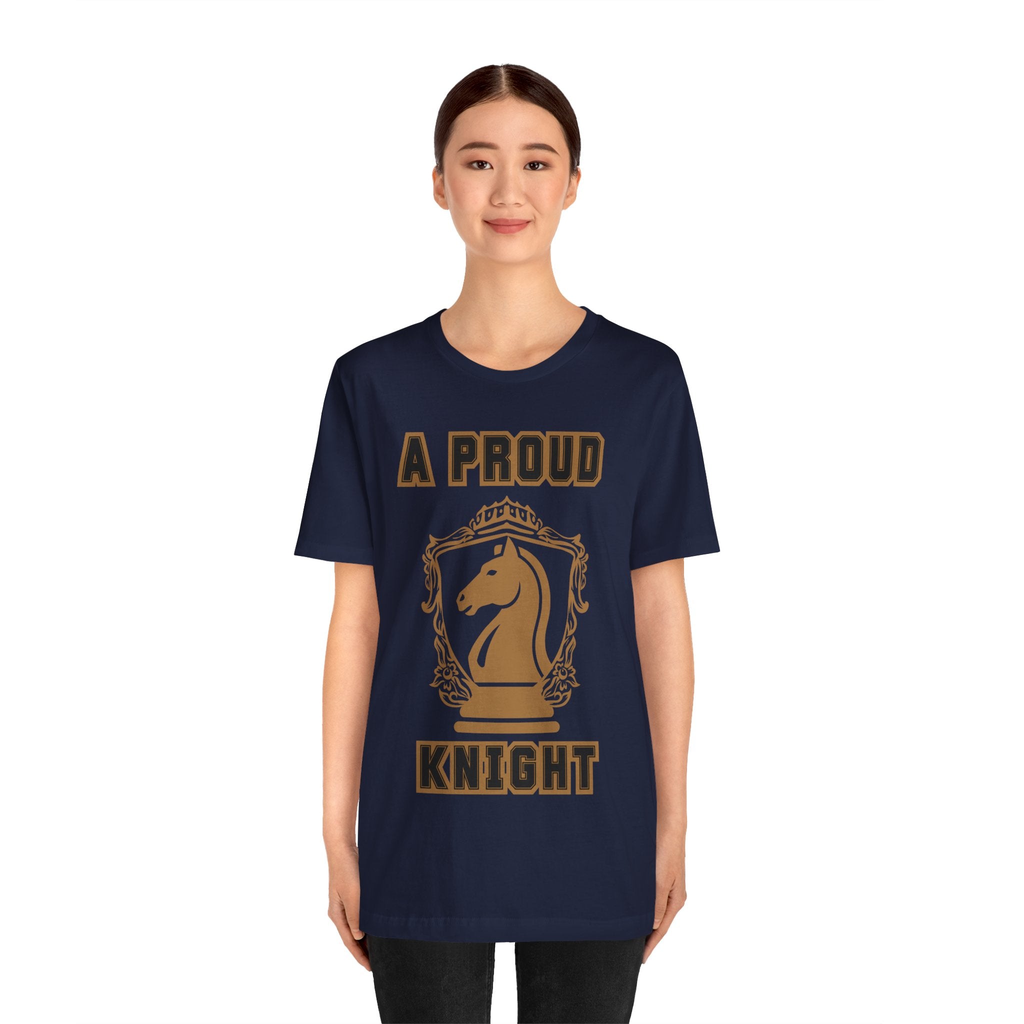 Woman wearing a navy graphic T-shirt with a gold chess knight design and the words A PROUD KNIGHT on the front.