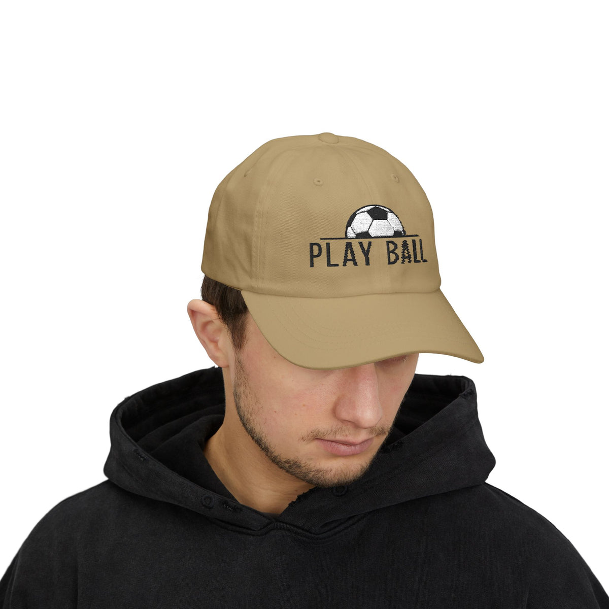 Man wearing a khaki cap with an embroidered soccer ball and Play Ball text on the front.