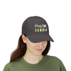 Woman wearing a dark grey baseball cap featuring the embroidered text Play TENNIS on the front.