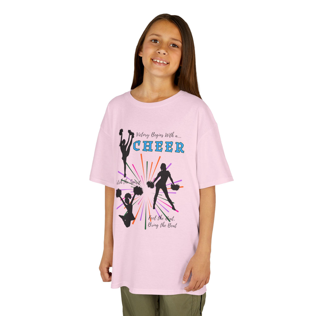 Young girl wearing a youth Gildan 5000B heavy cotton t-shirt in light pink with a Cheer Team design