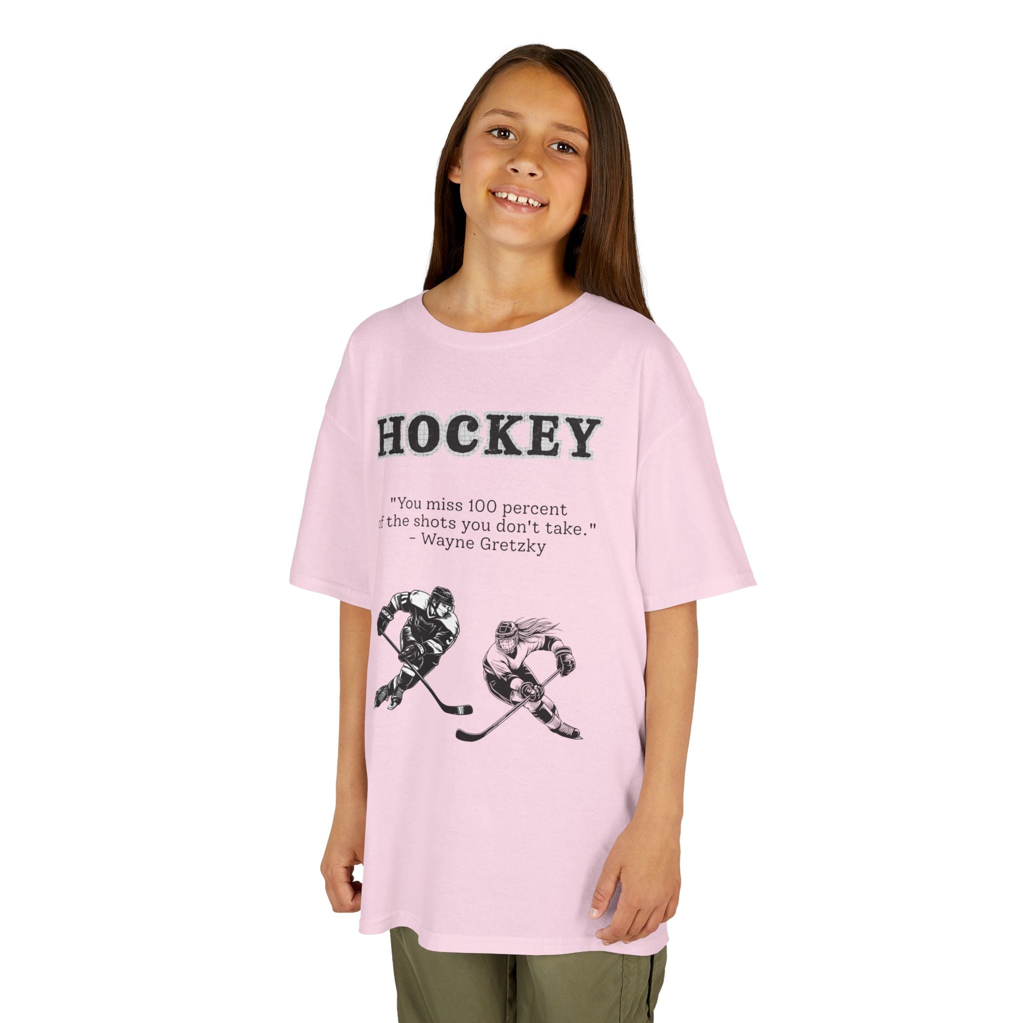 Young girl wearing a youth Gildan 5000B heavy cotton t-shirt in light pink with a Hockey text and graphic