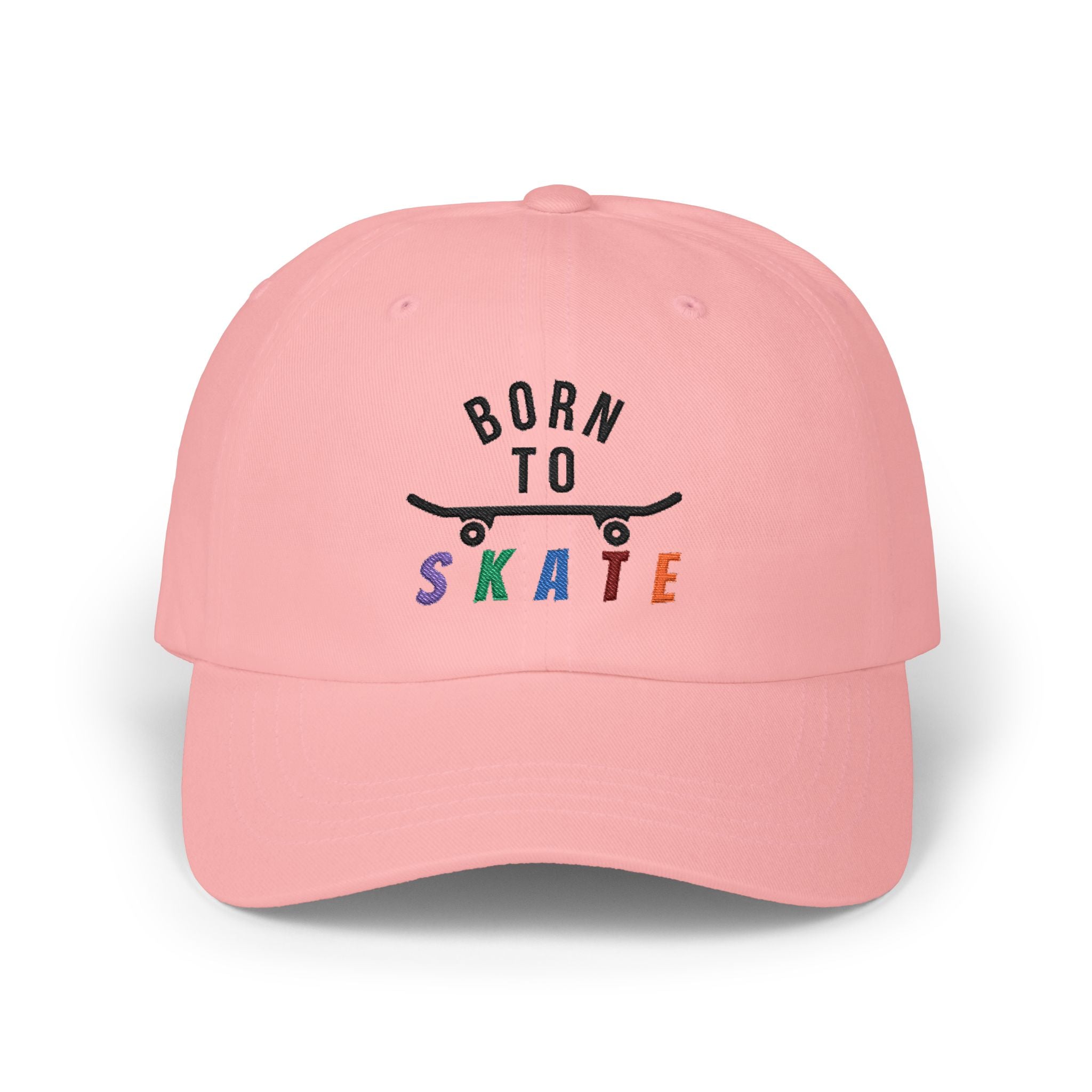 A pink baseball cap featuring a graphic on the front that reads BORN TO SKATE with a black skateboard silhouette and colorful lettering for SKATE.