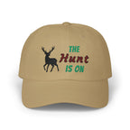 Khaki cap with an embroidered deer silhouette and The Hunt Is On text.