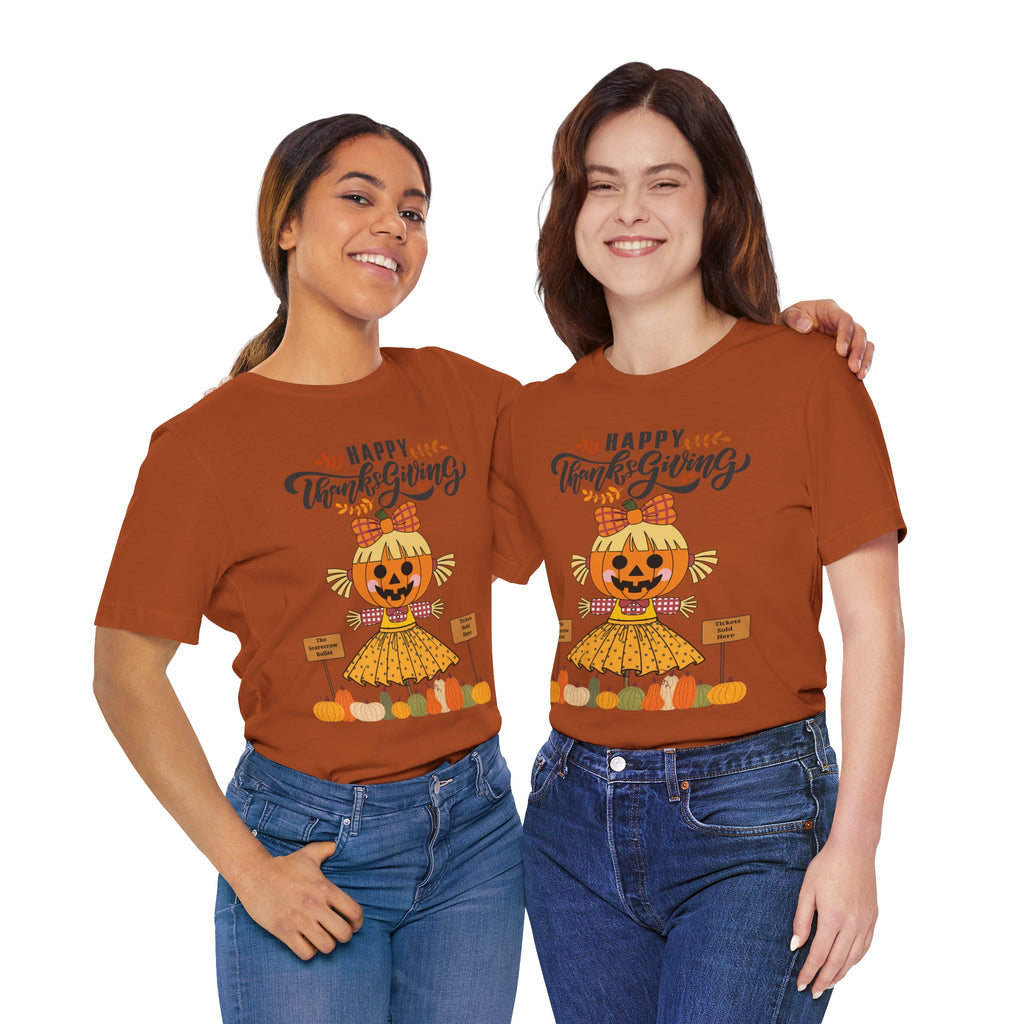 Two women wearing an autumn short-sleeve t-shirt with a Happy Thanksgiving graphic featuring a ballerina scarecrow design.