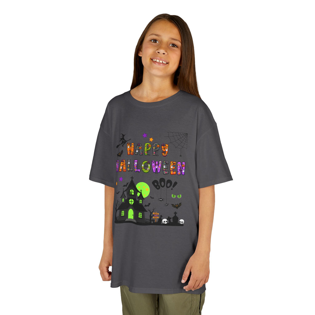 A young girl wearing a charcoal grey short-sleeve crewneck t-shirt featuring a colorful Happy Halloween graphic on the front, complete with a haunted house, witch, and spiderweb.