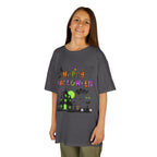 A young girl wearing a charcoal grey short-sleeve crewneck t-shirt featuring a colorful Happy Halloween graphic on the front, complete with a haunted house, witch, and spiderweb.
