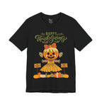 A black short-sleeve t-shirt with a Happy Thanksgiving graphic featuring a ballerina scarecrow design.