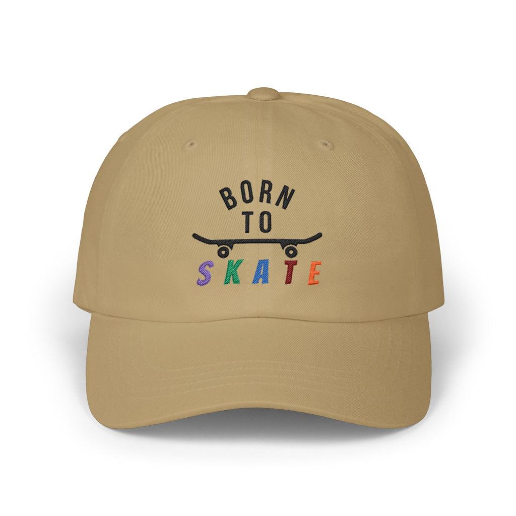 A khaki baseball cap featuring a graphic on the front that reads BORN TO SKATE with a black skateboard silhouette and colorful lettering for SKATE.