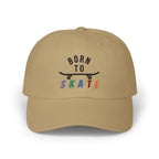 A khaki baseball cap featuring a graphic on the front that reads BORN TO SKATE with a black skateboard silhouette and colorful lettering for SKATE.