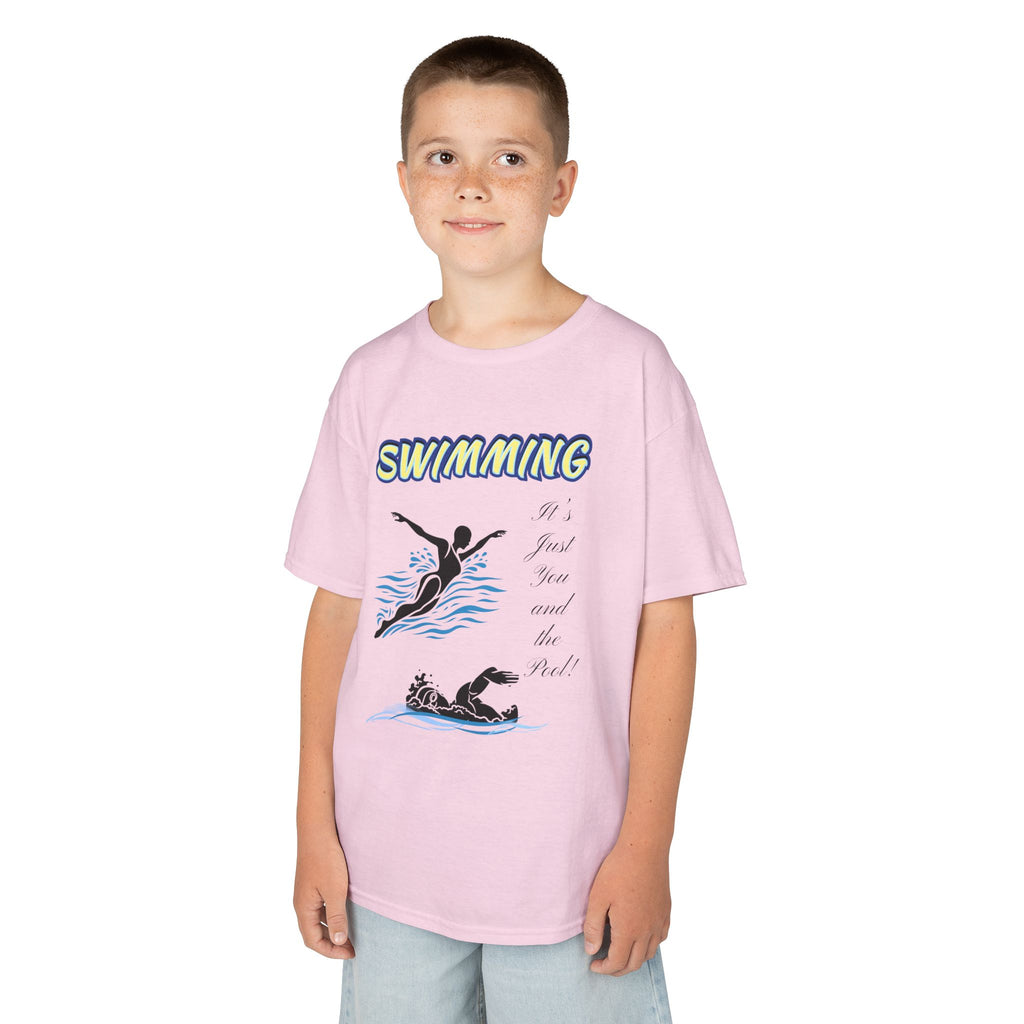 Young boy wearing a youth Gildan 5000B heavy cotton t-shirt in light pink with a Swimming text and graphic
