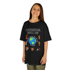 Young girl wearing a youth Gildan 5000B heavy cotton t-shirt in black with an International Dance Day theme 