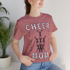 A woman wearing a heather mauve graphic t-shirt with CHEER GO TEAM MOM text and graphic on the front.