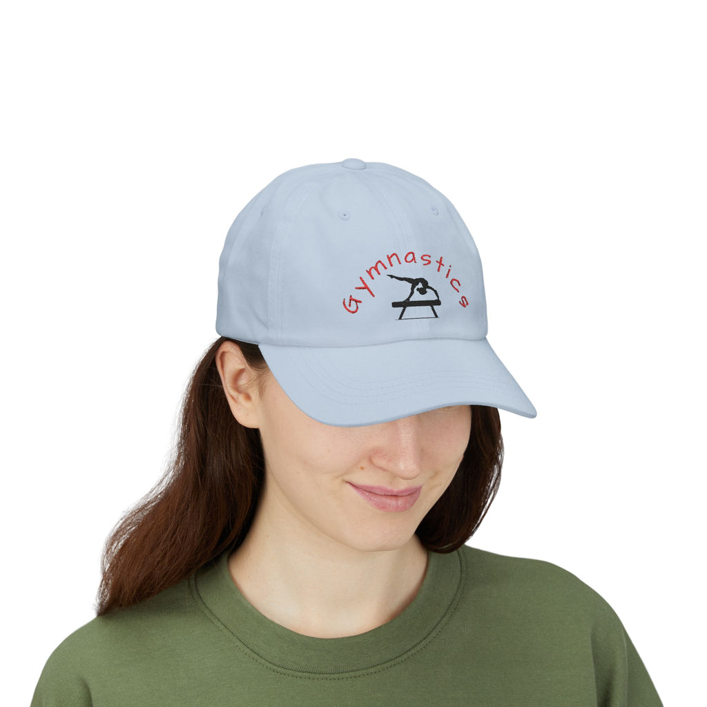 Woman wearing a light blue embroidered classic dad cap hat with a Gymnastics text and graphic 