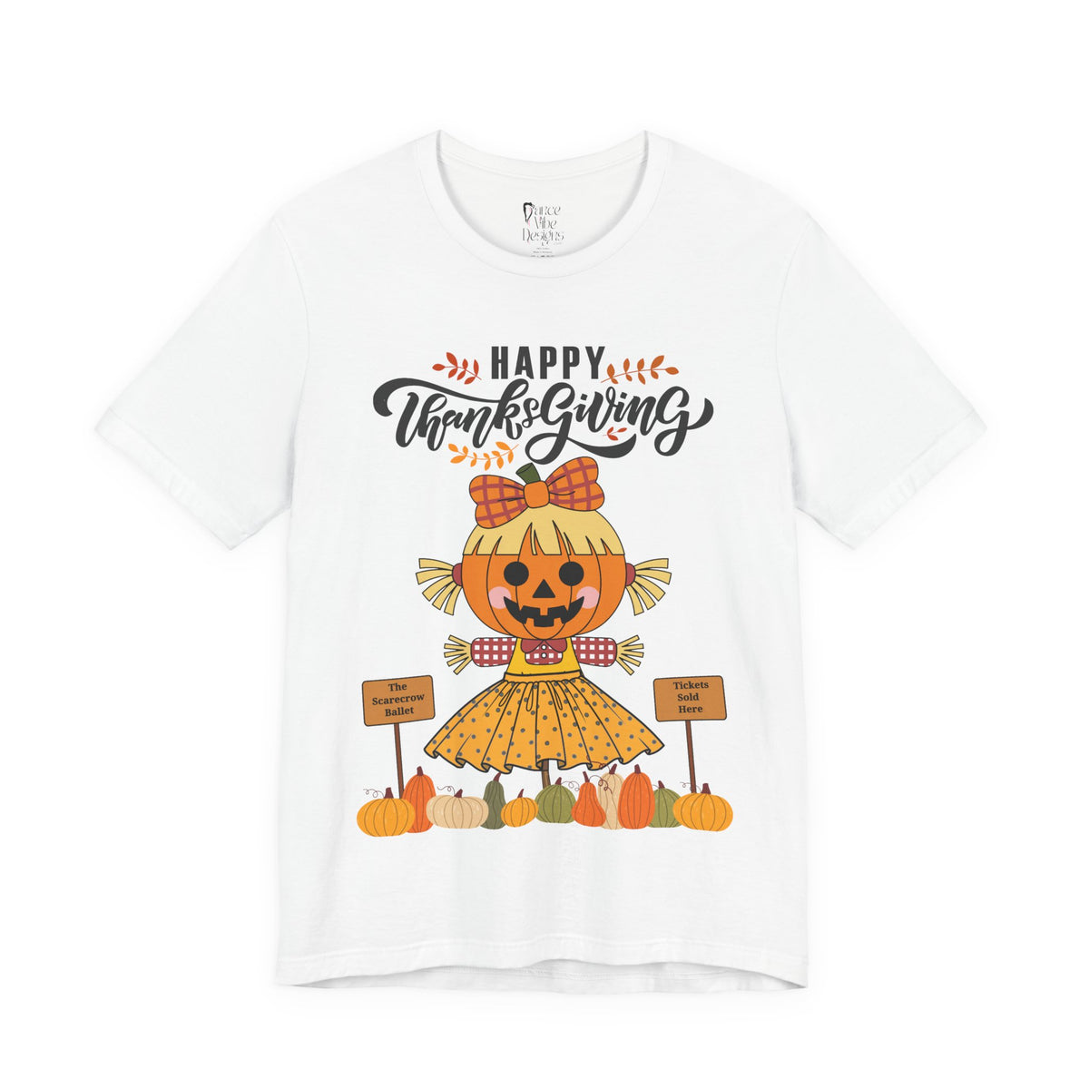 A white short-sleeve t-shirt with a Happy Thanksgiving graphic featuring a ballerina scarecrow design.