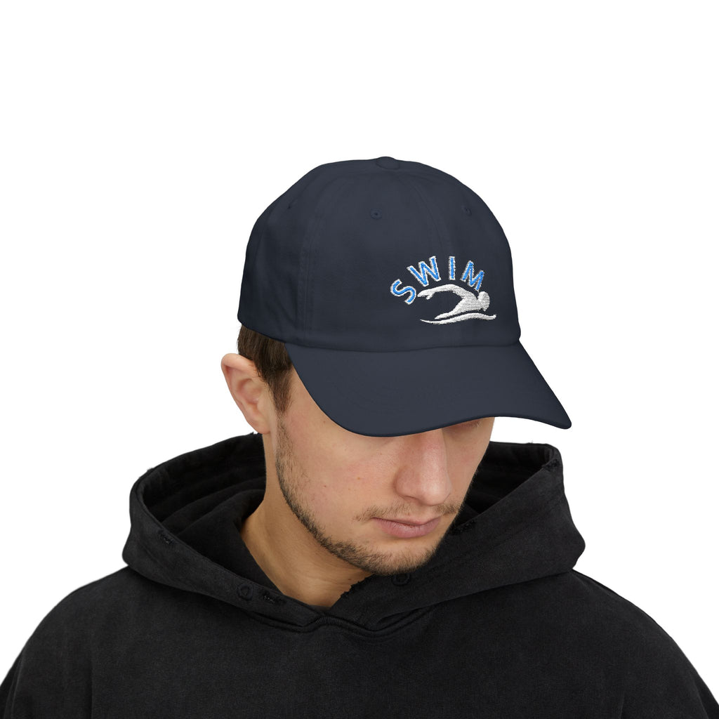 Man wearing a navy baseball cap featuring an embroidered design on the front with the word SWIM in light blue and a white silhouette of a swimmer.