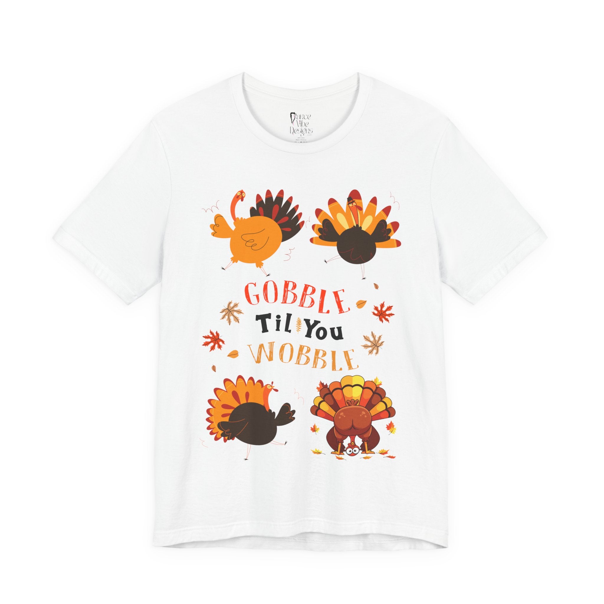 A white short-sleeve crewneck t-shirt featuring a colorful Thanksgiving graphic with cartoon turkeys and the text GOBBLE Til You WOBBLE.
