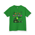 A green short-sleeve crewneck t-shirt featuring a colorful Happy Halloween graphic on the front, complete with a haunted house, witch, and spiderweb.