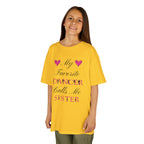 Young girl wearing a daisy short-sleeve t-shirt with a graphic text print on the front that reads My Favorite Dancer Calls Me Sister.