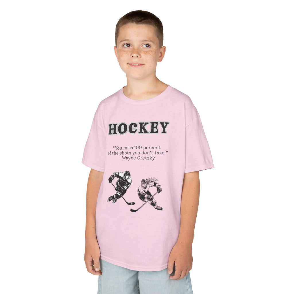 Young boy wearing a youth Gildan 5000B heavy cotton t-shirt in light pink with a Hockey text and graphic