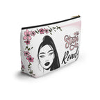 Makeup bag with a stylized face design and floral elements on a white background with black zipper side view