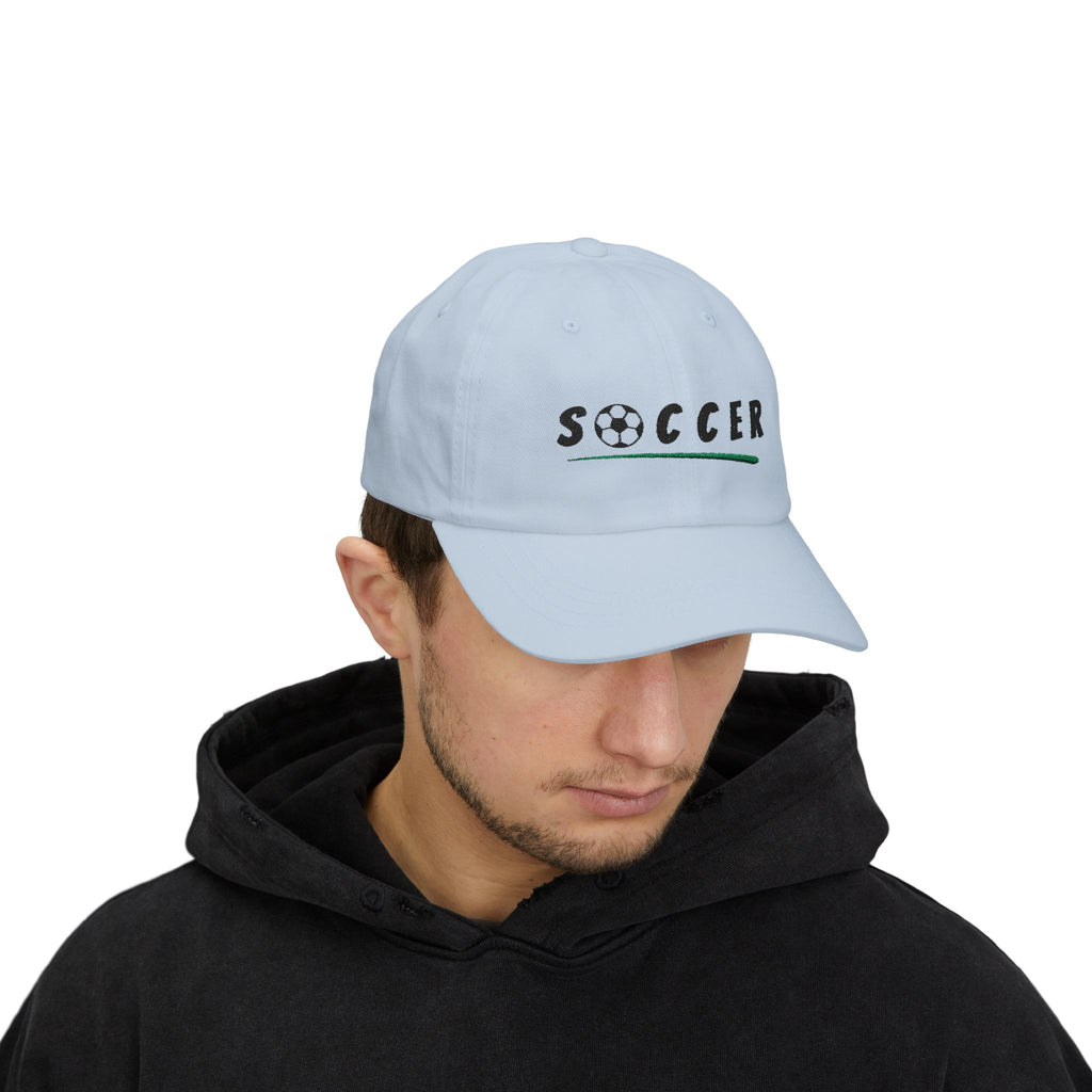 Man wearing a light blue embroidered classic dad cap hat with Soccer text and graphic