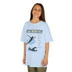 Young girl wearing a youth Gildan 5000B heavy cotton t-shirt in light blue with a Swimming text and graphic