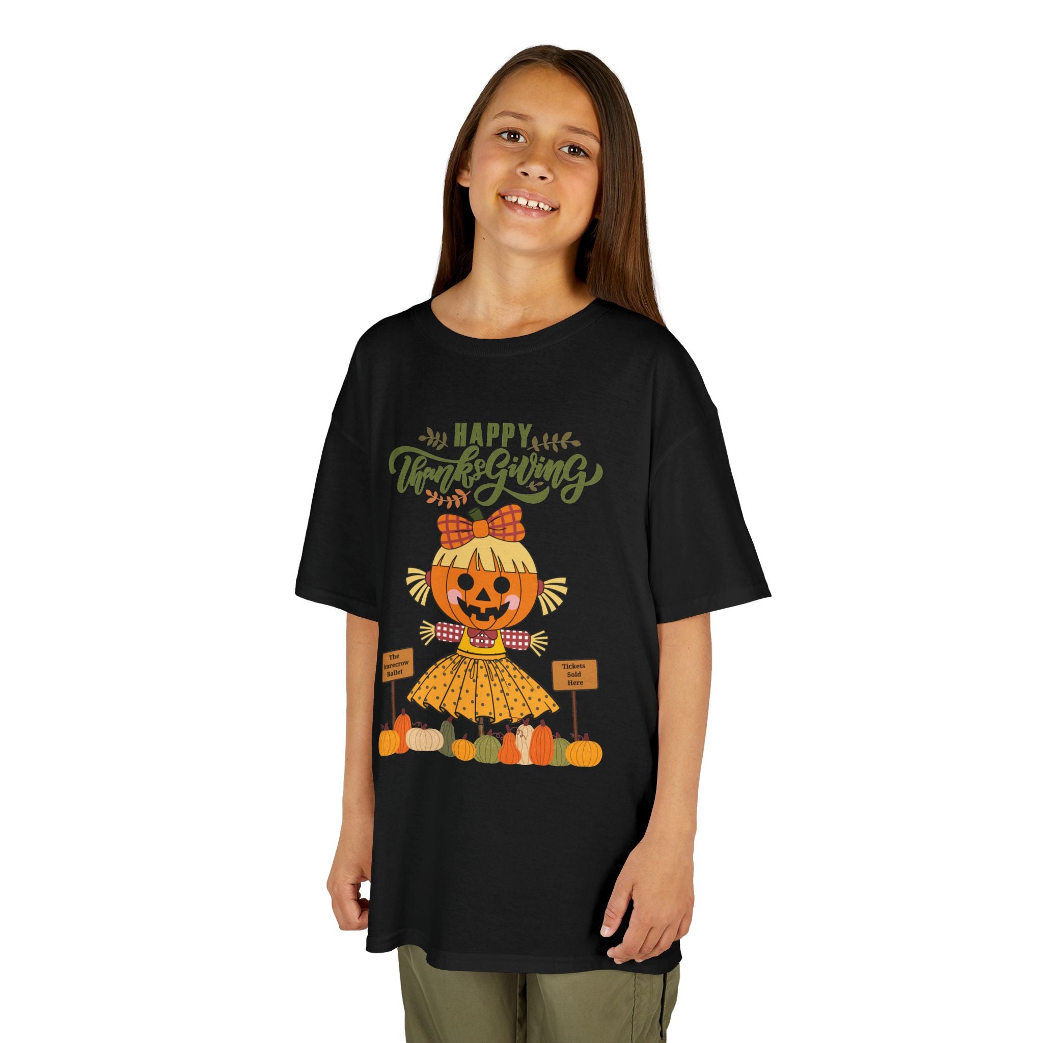 Young girl wearing a black Thanksgiving t-shirt with a scarecrow ballerina design and a Happy Thanksgiving text.
