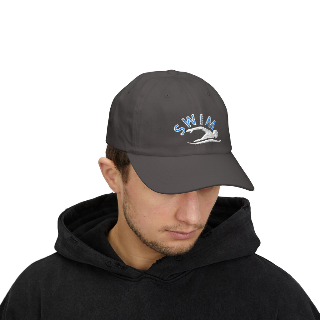 Man wearing a dark grey baseball cap featuring an embroidered design on the front with the word SWIM in light blue and a white silhouette of a swimmer.