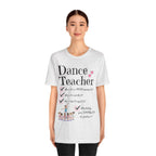 A young woman wearing an ash short-sleeve crewneck t-shirt featuring a text that reads Dance Teacher and a ballet class graphic.